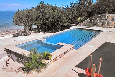 Immagine di una piscina fuori terra tradizionale rettangolare di medie dimensioni e dietro casa con una vasca idromassaggio e pavimentazioni in pietra naturale