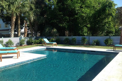 Foto de piscina elevada de estilo americano rectangular en patio trasero con losas de hormigón