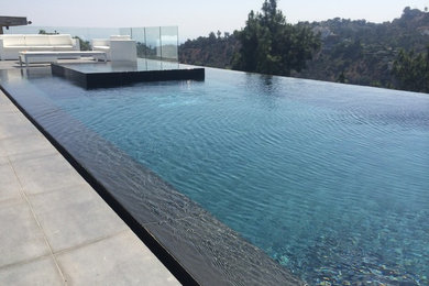 Modelo de piscina infinita moderna de tamaño medio rectangular en patio trasero