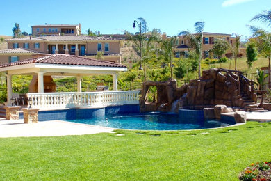 Mid-sized island style backyard stone and custom-shaped natural water slide photo in Los Angeles