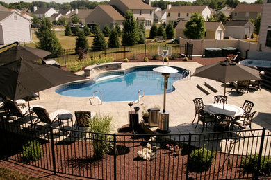 Example of a mid-sized classic backyard custom-shaped lap pool fountain design in Philadelphia