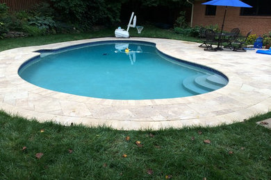 Inspiration for a large timeless backyard concrete paver and custom-shaped lap pool remodel in DC Metro
