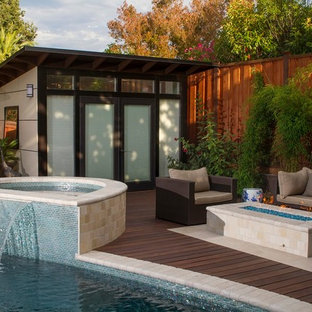 Foto de casa de la piscina y piscina actual, de tamaño medio, a medida, en patio trasero, con adoquines de piedra natural