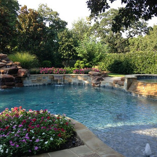 Foto di una grande piscina naturale chic personalizzata dietro casa con fontane e pedane