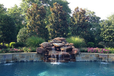 Idée de décoration pour une grande piscine naturelle et arrière tradition sur mesure avec un point d'eau et une terrasse en bois.