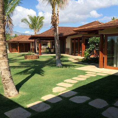 Large island style backyard concrete paver and rectangular infinity hot tub photo in Hawaii