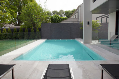 Идея дизайна: большой прямоугольный бассейн на заднем дворе в стиле модернизм с фонтаном