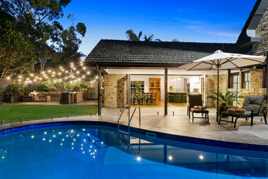 Imagen de piscina contemporánea tipo riñón en patio trasero con adoquines de piedra natural