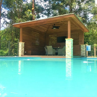 Immagine di una grande piscina monocorsia moderna personalizzata dietro casa con una dépendance a bordo piscina e pedane