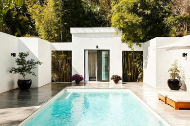 Imagen de casa de la piscina y piscina elevada moderna rectangular en patio lateral con entablado