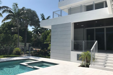 Example of a minimalist backyard rectangular pool house design in Miami