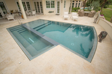 Mid-sized minimalist backyard stone and custom-shaped infinity pool photo in Miami