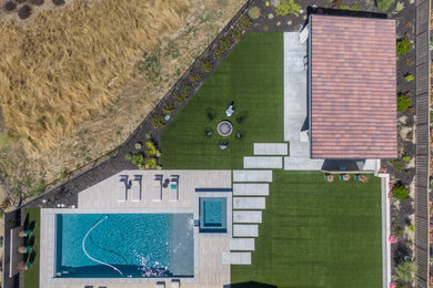 Ejemplo de casa de la piscina y piscina alargada contemporánea extra grande rectangular en patio trasero con adoquines de hormigón