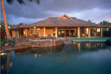 Ispirazione per una piscina naturale tropicale rotonda dietro casa con fontane
