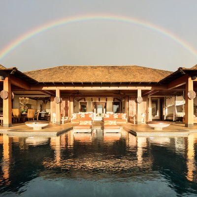 Hot tub - huge tropical backyard tile and custom-shaped infinity hot tub idea in Hawaii