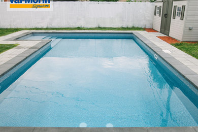 Example of a mid-sized classic backyard concrete paver and l-shaped pool design in Montreal
