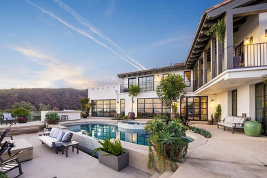 Tuscan backyard concrete and kidney-shaped pool photo in Los Angeles