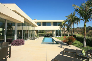 Example of a mid-sized minimalist concrete and rectangular lap pool design in Los Angeles