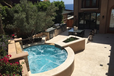 Immagine di una piccola piscina fuori terra design personalizzata dietro casa con fontane e lastre di cemento