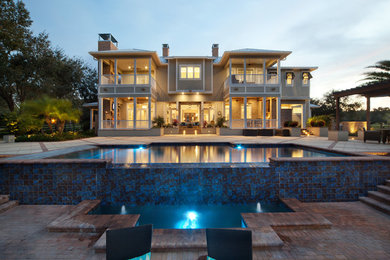 Inspiration for a large contemporary backyard brick and rectangular infinity pool remodel in Orlando