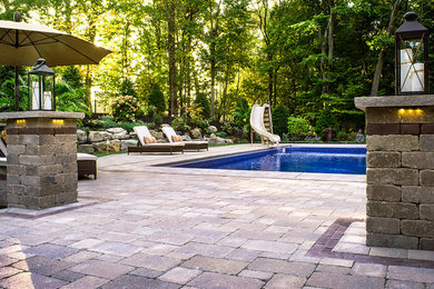 Inspiration for a large contemporary backyard concrete paver and rectangular water slide remodel in Other