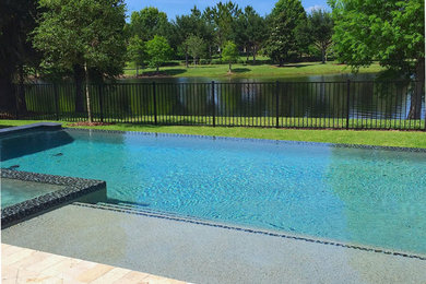 Imagen de piscinas y jacuzzis alargados clásicos grandes rectangulares en patio trasero con adoquines de piedra natural