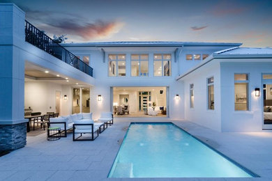 Pool fountain - huge contemporary backyard stone and rectangular lap pool fountain idea in Miami
