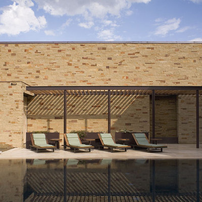 Large trendy courtyard tile and rectangular infinity pool photo in Austin