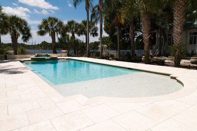 Esempio di una piscina di medie dimensioni e dietro casa con pavimentazioni in cemento e una vasca idromassaggio