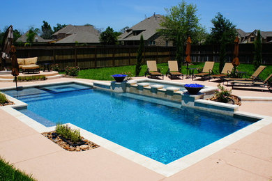 Modelo de piscinas y jacuzzis alargados contemporáneos de tamaño medio rectangulares en patio trasero con losas de hormigón