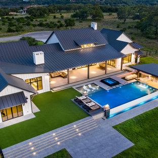 Foto di una grande piscina a sfioro infinito moderna rettangolare dietro casa con pedane
