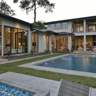 Design ideas for a large contemporary backyard rectangular lap pool in Houston with a water feature and concrete slab.