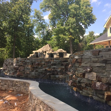 Lakeside view of serene waterfall/trickle is backside of custom pool catch basin