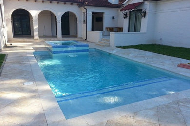 Photo of a medium sized contemporary swimming pool in New Orleans with natural stone paving.