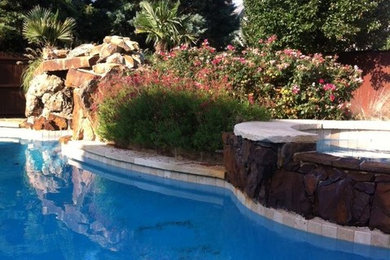 Modelo de piscina con fuente clásica grande a medida en patio trasero con adoquines de piedra natural