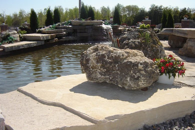Example of a mid-sized classic backyard stone and custom-shaped natural pool design in Toronto