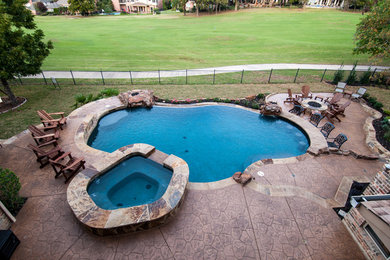 Mid-sized backyard custom-shaped natural hot tub photo in Dallas with decking