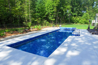 Pool - backyard concrete paver and custom-shaped pool idea in Grand Rapids