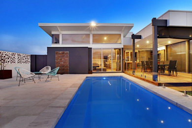 Ejemplo de casa de la piscina y piscina alargada de estilo americano a medida en patio trasero