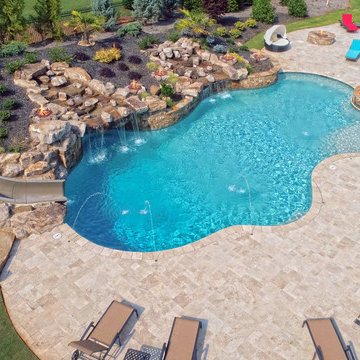 Large Custom Freeform pool with Slide, Grotto, Waterfall, and Travertine
