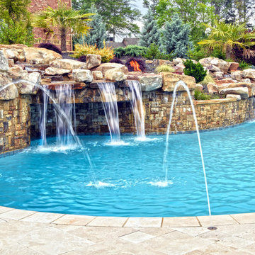 Large Custom Freeform pool with Slide, Grotto, Waterfall, and Travertine