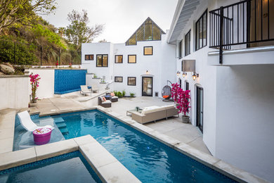 Diseño de piscinas y jacuzzis alargados actuales de tamaño medio a medida en patio trasero con losas de hormigón