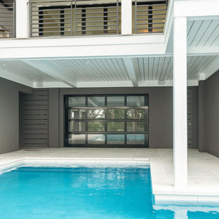Immagine di una grande piscina moderna a "L" dietro casa con pavimentazioni in cemento