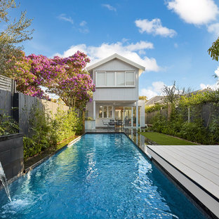 Photo of a small contemporary backyard rectangular lap pool in Sydney with a water feature and decking.