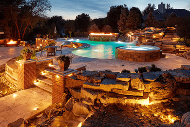 Large backyard stone and custom-shaped infinity pool house photo in Omaha