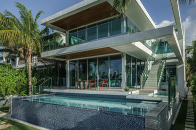Photo of a medium sized modern back rectangular infinity swimming pool in Miami.