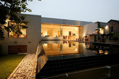 Foto de piscinas y jacuzzis infinitos actuales rectangulares en patio trasero con entablado