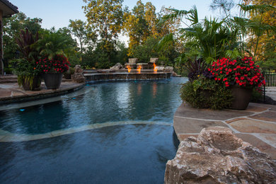 Example of a mid-sized classic backyard stone and custom-shaped natural pool fountain design in Kansas City