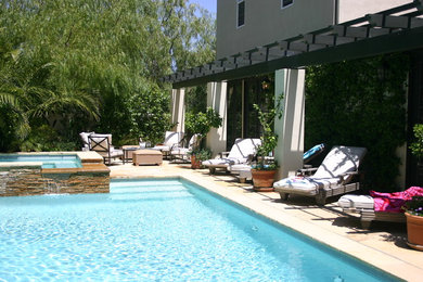 Diseño de casa de la piscina y piscina natural mediterránea grande a medida en patio trasero con adoquines de piedra natural