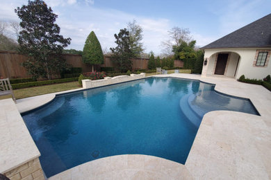Example of a mid-sized tuscan backyard tile and custom-shaped lap pool fountain design in Houston